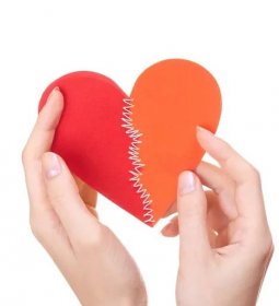 Valentýn srdce sešité ze dvou polovin v rukou ženy — Stock obrázek