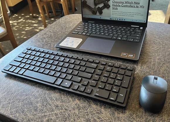 Dell Silent Keyboard and Mouse combo connected to a laptop on a cafe table.