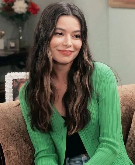 a woman sitting on top of a brown couch