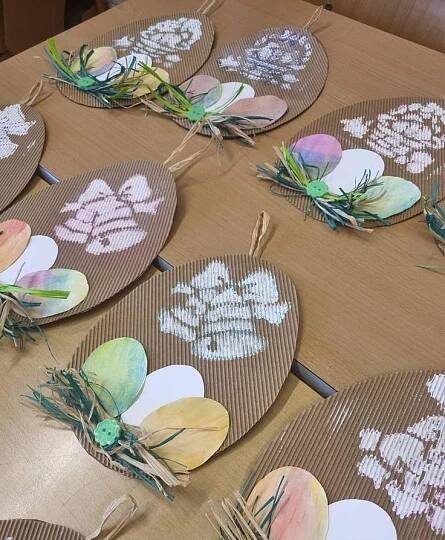 paper plates decorated with flowers and leaves are sitting on a wooden tablecloth covered table