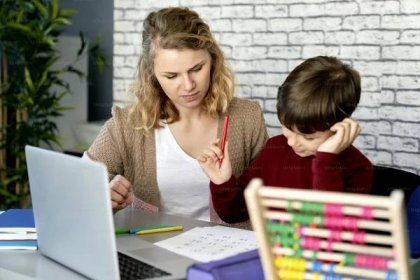 Mother helping her son while studying