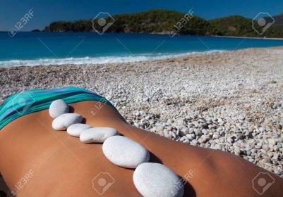 Beautiful woman getting hot stones treatment out on Oludeniz beach - 39510483