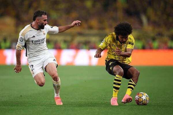 Karim Adeyemi z Dortmundu v akci proti Dani Carvajalovi z Realu Madrid