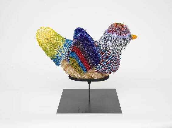 Sculpture of bird covered in colorful beadwork.