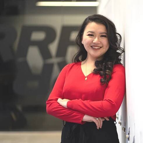 Maria Lin smiling with arms crossed. 