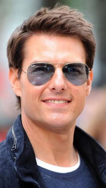 a man wearing sunglasses and smiling for the camera