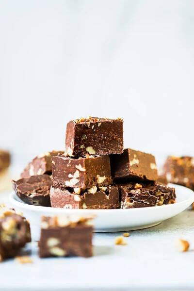 chocolate fudge squares stacked on top of each other on a plate