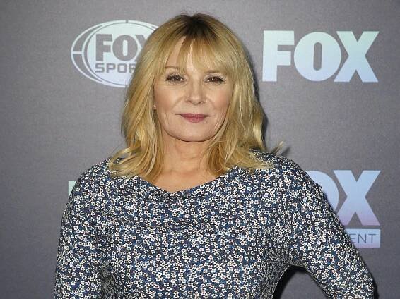 Kim Cattrall in printed dress on gray background