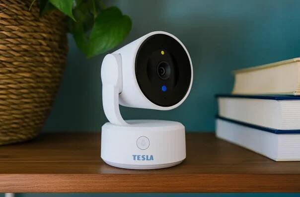 TESLA Smart Camera Omni 360 na policce vedle knizek a rostliny