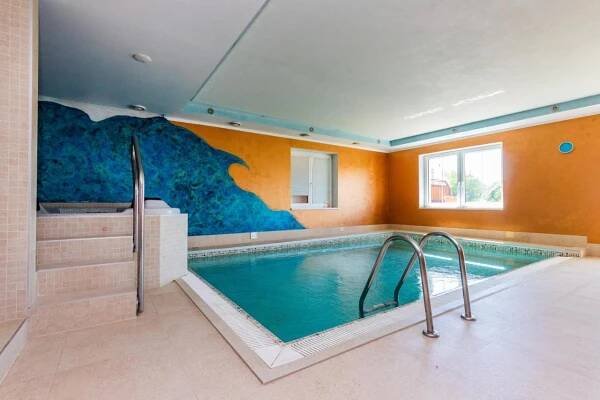 a swimming pool in a large room with a swimming pool at Hotel České Žleby in Stožec