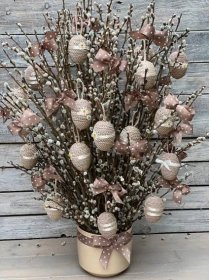 a vase filled with lots of ornaments on top of a wooden floor next to a wall