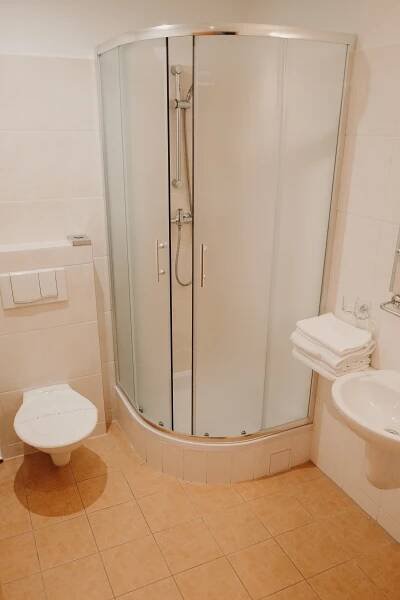 a bathroom with a shower and a toilet and a sink at Golf Hotel Austerlitz in Slavkov u Brna