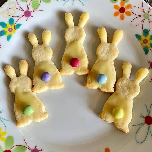 some bunny cookies are on a plate with candy