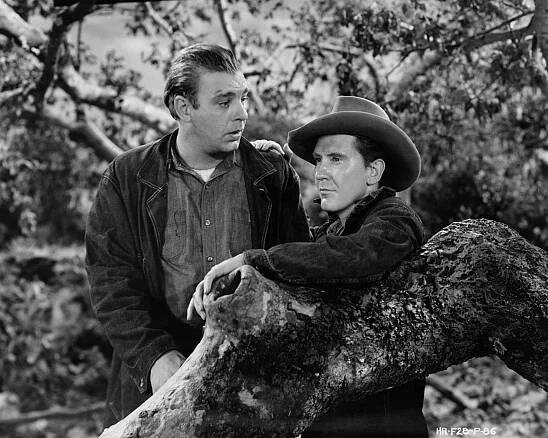 Movie still from the 1939 Hal Roach production of Steinbeck's 'Of Mice and Men.' Here, George (Burgess Meredith) talks with his oafish friend, Lennie (Lon Chaney, Jr.).