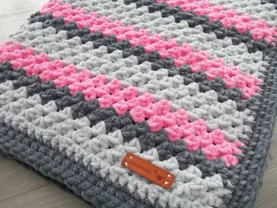 a crocheted blanket with pink and gray designs