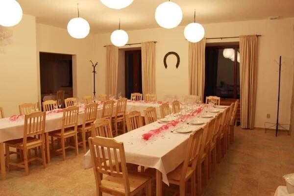 a room with long tables and chairs with pink flowers on them at Penzion Starý Pivovar in Křtiny