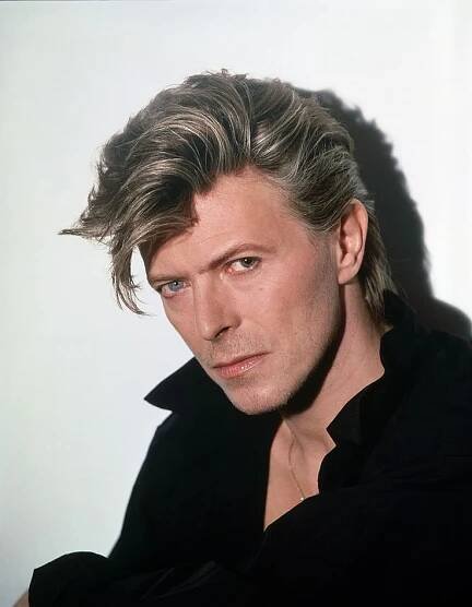 a man with blonde hair and black shirt