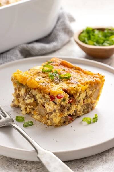 Slice of sausage breakfast casserole on a white plate.
