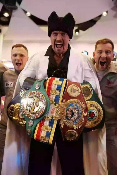 Oleksandr Usyk poses for a photo with his belts