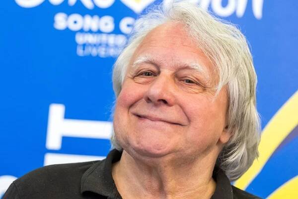 Peter Urban steht vor dem ESC-Logo (Symbolbild): Der 75-Jährige musste einen TV-Auftritt nach einem schweren Sturz absagen.