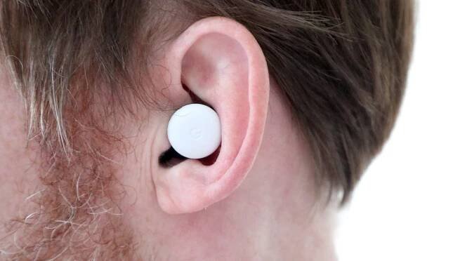 Close-up photograph of ear bud in a man's ear.