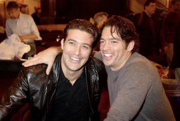 Craig Bierko and Harry Connick Jr. in rehearsal for Thou Shalt Not. They are smiling and have arms around one another.
