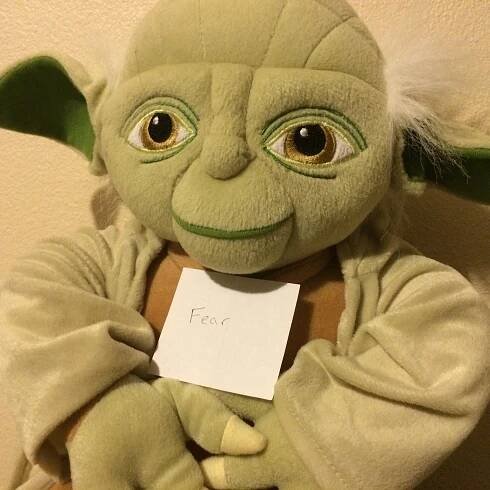 Yoda doll holding Fear sign