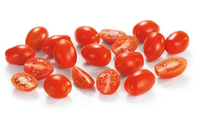 Celá a půlená červená rajčata cherry.