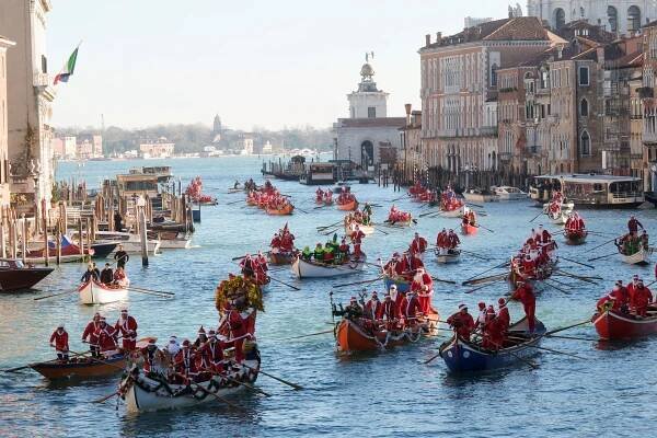 People dressed as Santa Claus row during a Christmas regatta along the Grand Canal in Venice