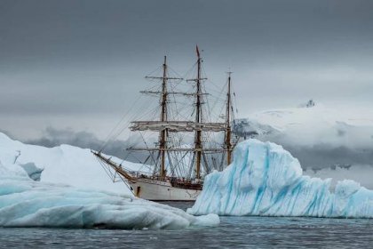 Bark Europa with icebergs along the coast of the Antarctic Peninsula