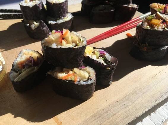 Sushi rolls on a wooden board.
