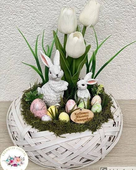 an easter basket with white tulips, eggs and bunny figurines in it