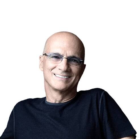 Jimmy Iovine wearing a dark T-shirt and glasses while smiling.