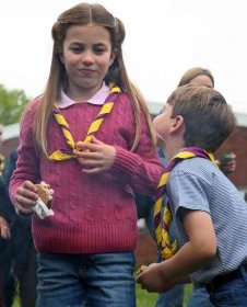 Princess Charlotte of Wales (R) and her brother Britain's Prince Louis of Wales (R) eat marshmallow biscuits as they take part in the Big Help Out, during a visit to the 3rd Upton Scouts Hut