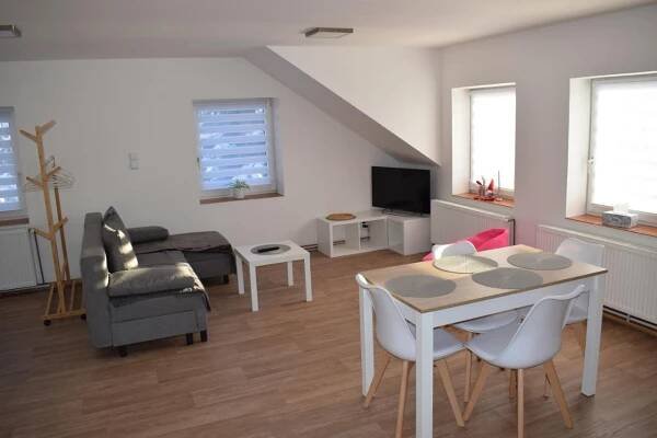 a living room with a table and chairs and a couch at Penzion Víra in Velké Losiny
