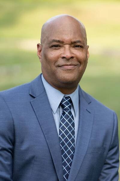Professional headshot of a charismatic community leader, projecting strength and empathy
