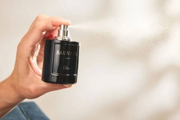 A person sprays the Dior Sauvage Elixir bottle