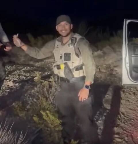 Deputy Alejandro Gomez placing a baby bunny in a vehicle.