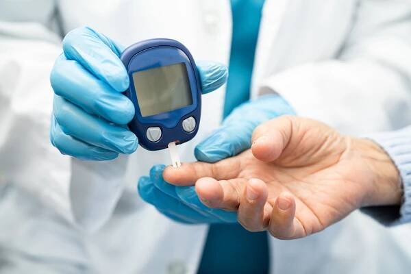 Doctor checks diabetes with finger lancet.