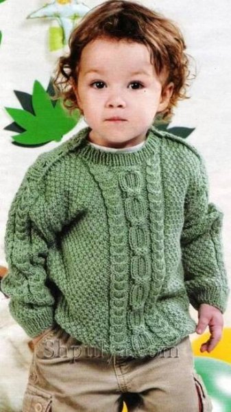 a little boy wearing a green sweater and khaki pants