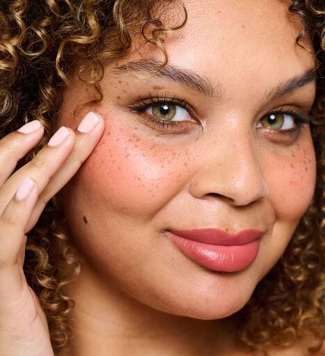 Model wearing and applying Colour Wonder Lip and Cheek Balm Au Naturelle