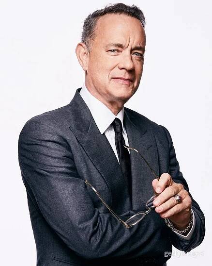 a man in a suit and tie is holding some glasses with both hands on his chest