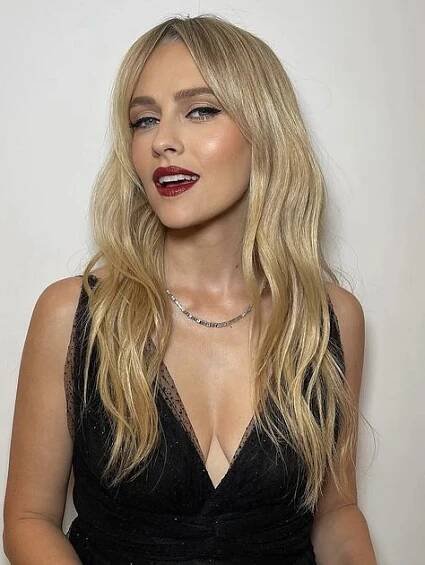 a woman with long blonde hair wearing a black dress and red lipstick on her lips