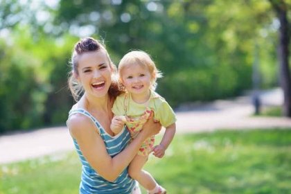 Usmívající se matka a dítě hraje v parku — Stock fotografie