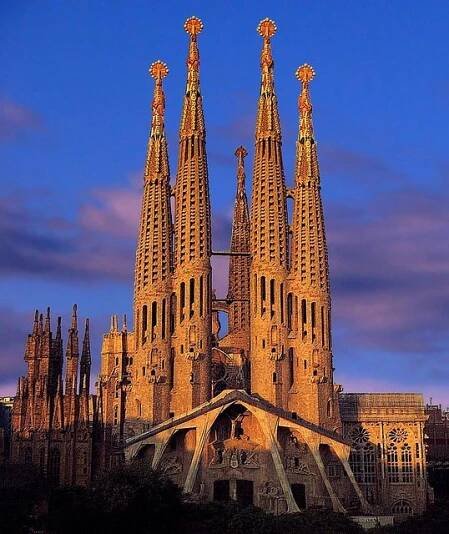 the large cathedral has many spires on it's sides and is lit up at night