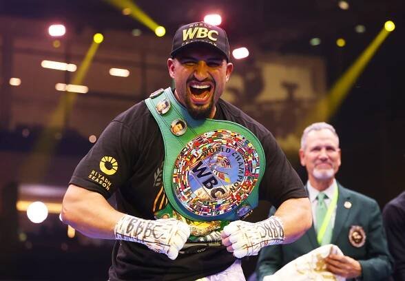 Agit Kabayel celebrating a boxing victory with the WBC Interim World Heavyweight Title belt.