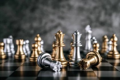 Gold and silver chess on chess board game for business metaphor leadership concept