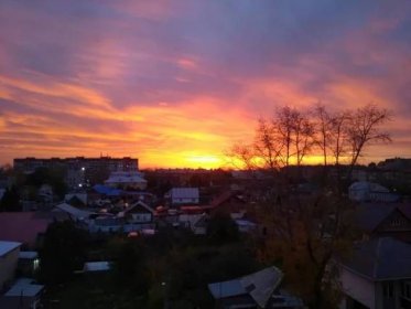 Krásný západ slunce ve městě s těžkými oranžovými mraky — Stock fotografie