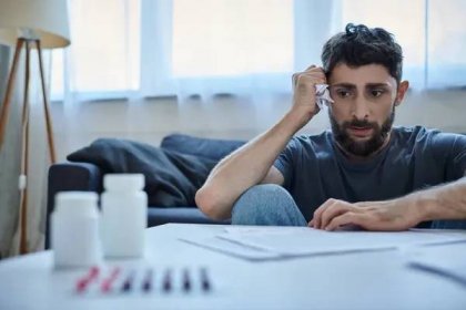 Úzkostlivý muž v neformální domácí košili při pohledu na smlouvy a papíry a starosti hodně, duševní zdraví — Stock obrázek
