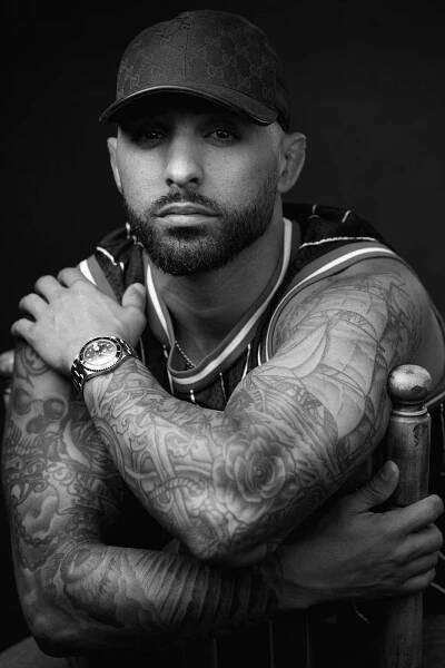A black and white photo of a man with tattoos captured by Eric Campbell Photography, a professional photographer specializing in business headshots based in Fort Lauderdale.